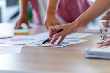 Ofiste şirketin istatistiklerine işaret eden iş adamlarının elleri.