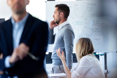 Yakışıklı genç işadamı coworking alanı cep telefonu konuşuyor.