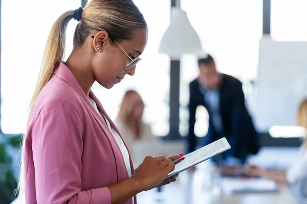 Giovane donna d'affari intelligente che lavora con tablet digitale sul posto di coworking . — Foto Stock