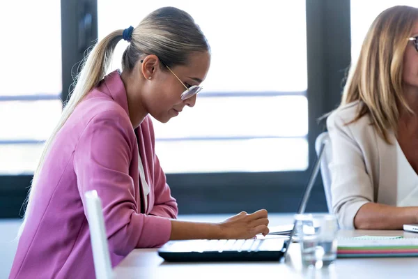 Slimme jonge zakenvrouw werken met digitale tablet op coworking place. — Stockfoto