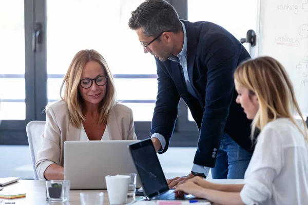 Leende affärsman pratar med kollegor i mötet om Coworking rymden. — Stockfoto