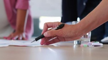 Ofiste şirketin istatistiklerine işaret eden iş adamlarının ellerinin yakın çekim.
