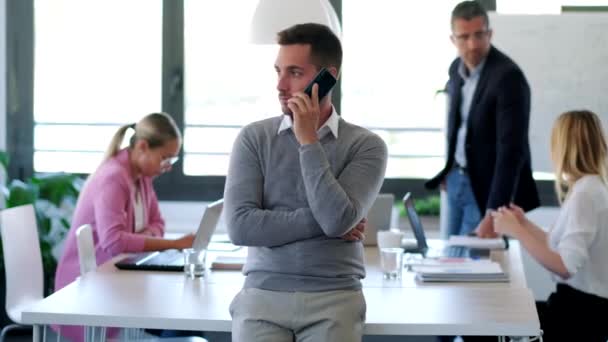 Knappe jonge zakenman praten op mobiele telefoon op coworking ruimte. — Stockvideo