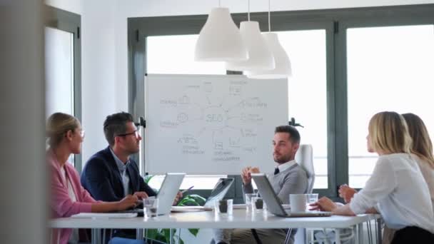 Geschäftsleute diskutieren bei Besprechung im Büro gemeinsam im Konferenzraum. — Stockvideo