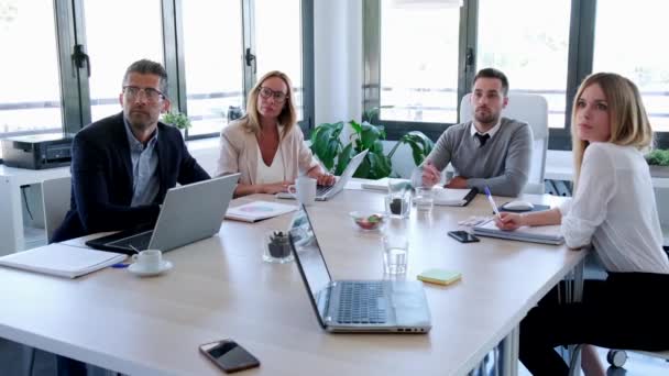 Empresarios tomando notas con laptop y prestando atención en conferencia sobre coworking place . — Vídeos de Stock