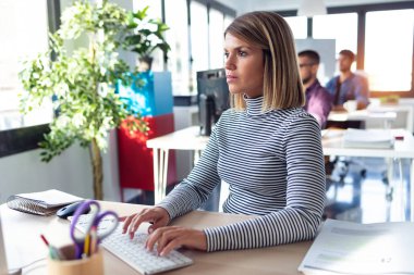 Modern başlangıç ofisinde bilgisayarla çalışan yazılım geliştiricisi.