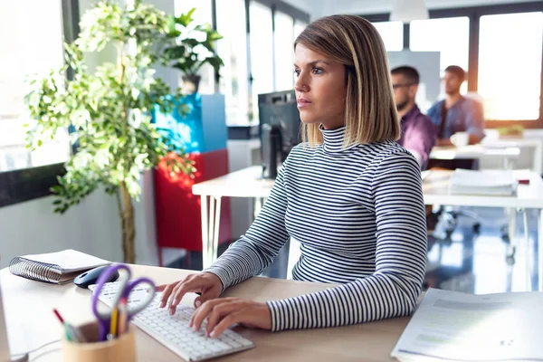 Modern başlangıç ofisinde bilgisayarla çalışan yazılım geliştiricisi.