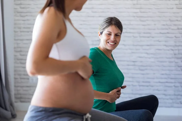 Hermosa mujer embarazada con su fisioterapeuta haciendo ejercicios de pilates preparándose para el parto . — Foto de Stock