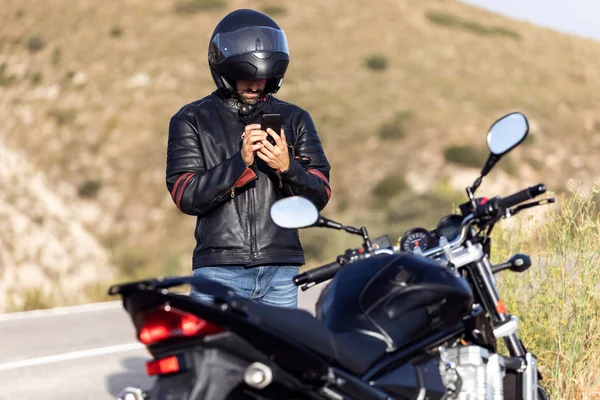 Homme motard parlant au téléphone à l'assurance de sa moto après avoir subi une panne sur la route . — Photo