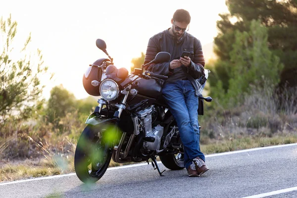 Hombre motociclista hablando por teléfono al seguro de su motocicleta después de haber sufrido una avería en la carretera . —  Fotos de Stock