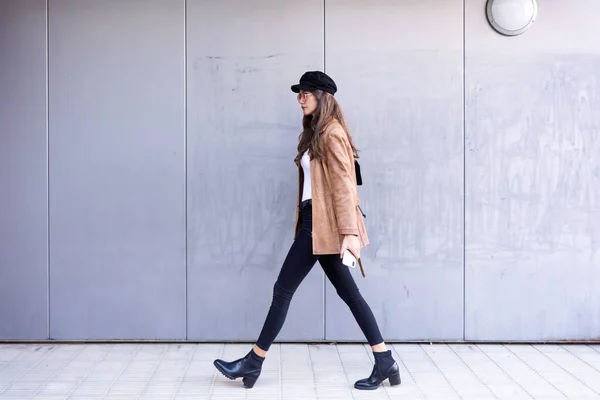 Jolie jeune femme marchant tout en tenant son téléphone portable dans la rue . — Photo