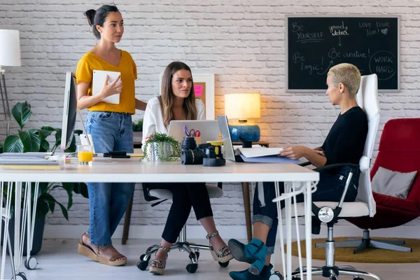 Tre moderna kvinnliga entreprenörer som pratar om nya idéer till nästa arbete på en gemensam arbetsplats. — Stockfoto