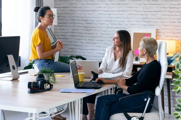 共同作業場で次の仕事をするための新しいアイデアについて話す3人の現代女性起業家. — ストック写真