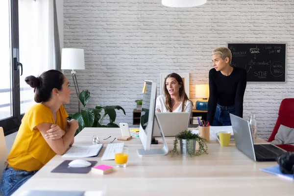 Tre moderna kvinnliga entreprenörer som pratar om nya idéer till nästa arbete på en gemensam arbetsplats. — Stockfoto