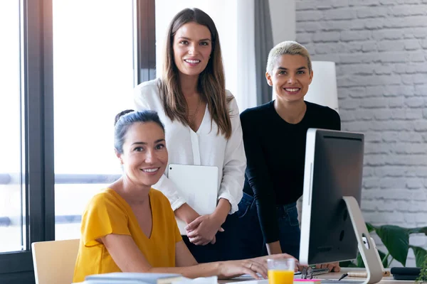 Moderna tre entreprenör kvinnor tittar på kameran när du arbetar på kontoret. — Stockfoto