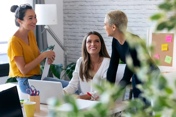 Tre imprenditrici moderne che parlano di nuove idee per il prossimo lavoro in uno spazio di lavoro congiunto . — Foto Stock