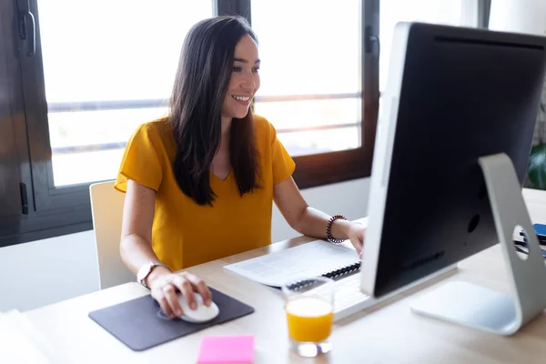 Sourire jeune femme d'affaires travaillant avec son ordinateur dans le bureau . — Photo