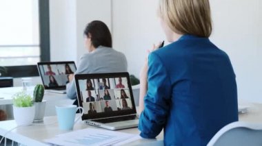 İki iş kadınının, çeşitli meslektaşlarıyla iş yerindeki bilgisayarlı brifingde video görüşmesi yaparken konuştuğu bir video..