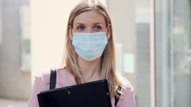 Yüzü maskeli güzel bir sarışının videosu. Dosyasıyla caddede beklerken bekliyor..