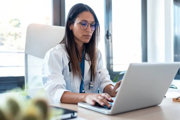 Inyección Confiada Joven Doctora Usando Teléfono Móvil Mientras Trabajaba Computadora — Foto de Stock