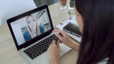 Kadın bir doktorun evdeki bilgisayarla kadın bir hastayla ilgilendiği video görüntüsü..