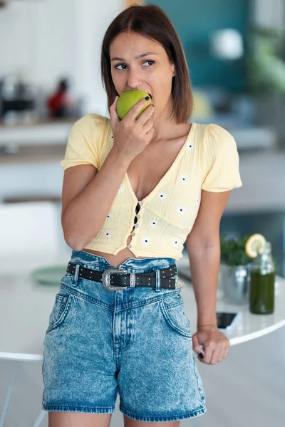 Strzał Pięknej Młodej Kobiety Jedzącej Zielone Jabłko Kuchni Domu — Zdjęcie stockowe