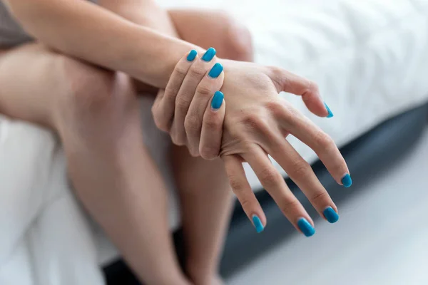 Yatakta kasları ağrıyan genç bir kadının fotoğrafını çek. Fibromiyalji kavramları.