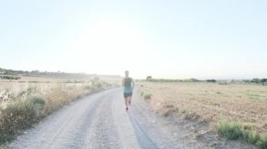 Atletik, güçlü, olgun bir sporcunun sahada koşuşunun videosu..