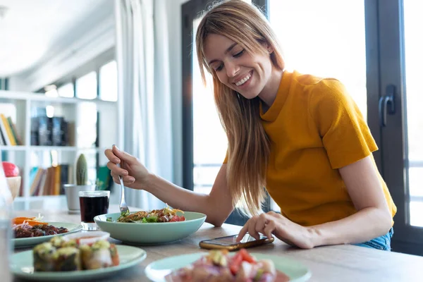 Colpo Donna Sorridente Mangiare Cibo Sano Mentre Utilizza Suo Telefono — Foto Stock