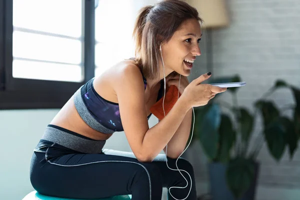 Spor Salonundaki Spor Topu Üzerinde Otururken Cep Telefonunu Kullanan Genç — Stok fotoğraf