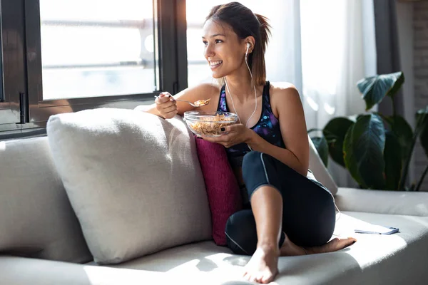 Foto Una Joven Deportista Comiendo Tazón Muesli Mientras Escucha Música —  Fotos de Stock