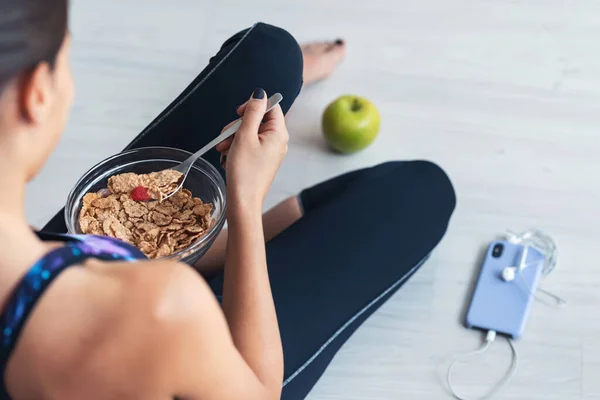 Yerde Oturmuş Müsli Yiyen Genç Sportif Bir Kadının Yakın Çekimi — Stok fotoğraf