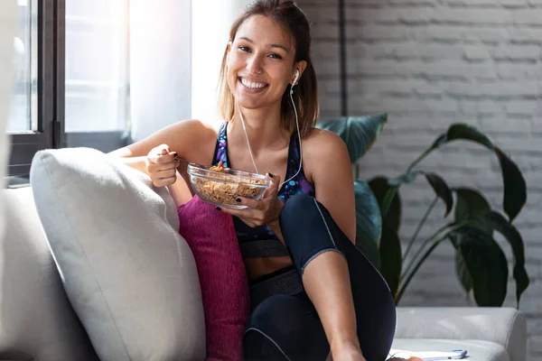 Foto Una Joven Deportista Comiendo Tazón Muesli Mientras Escucha Música — Foto de Stock