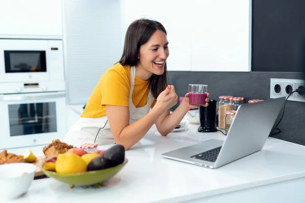 부엌에 디톡스 소프트 스무디를 친구와 노트북 컴퓨터를 온라인으로 전화를 아름다운 — 스톡 사진