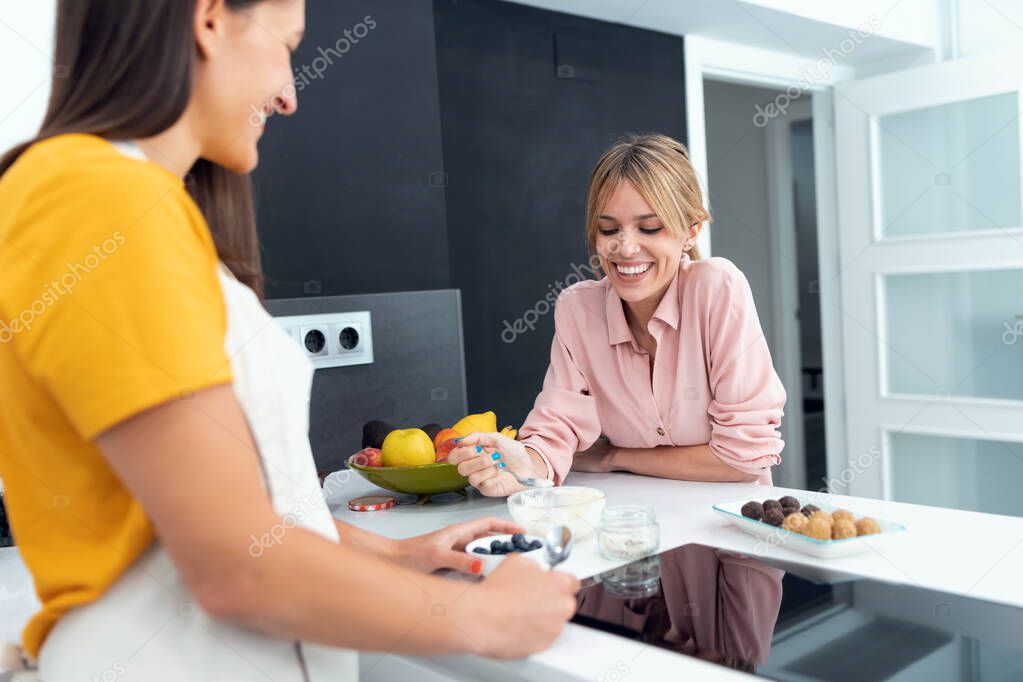 Shot of two beautiful women tasting the healthy dishes they have prepared in the kitchen at home.