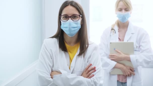 医院的专业年轻女医生戴着医疗面罩看着相机的视频 — 图库视频影像