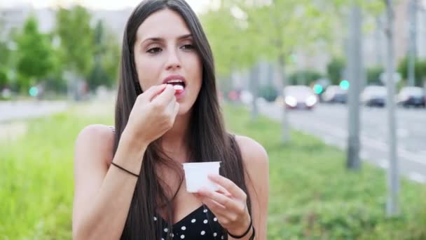 Видео Красивая Молодая Женщина Улыбается Ест Мороженое Стоя Улице — стоковое видео