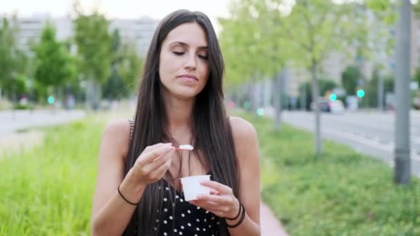 Видео Красивая Молодая Женщина Улыбается Ест Мороженое Стоя Улице — стоковое видео