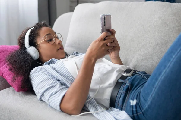 Strzał Pięknej Młodej Kobiety Słuchającej Muzyki Słuchawkami Podczas Korzystania Smartfona — Zdjęcie stockowe