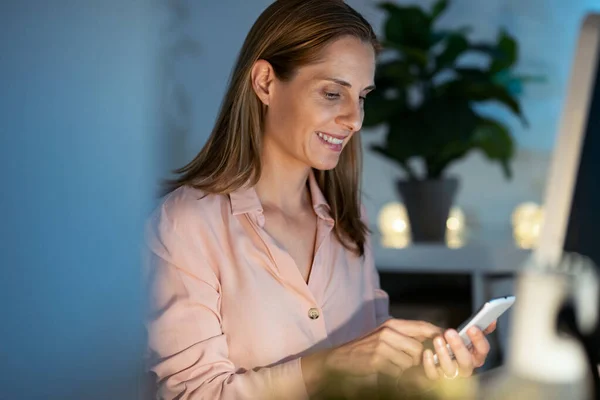 Tiro Mujer Negocios Madura Sonriente Usando Teléfono Inteligente Mientras Trabaja —  Fotos de Stock