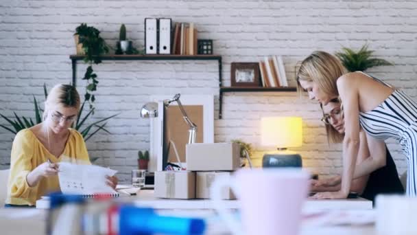 スタートアップの中小企業でデジタルタブレットで新しいアイデアを示しながら コンピュータで作業している3つの美しいフリーランスのビジネス女性の売り手のビデオ — ストック動画