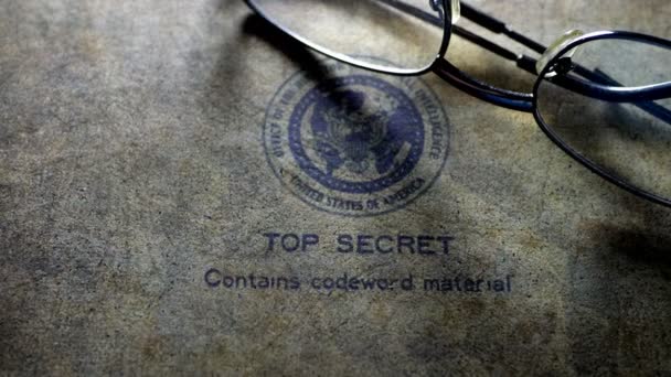 Reading glasses on top secret document — Stock Video