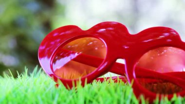 Yeşil çimlerde kırmızı güneş gözlükleri