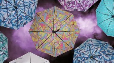 Mor gökyüzüne karşı renkli şemsiyeler