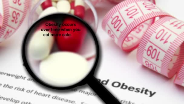 Aşırı kilolu ve obezite kavramı üzerine büyüteç — Stok video