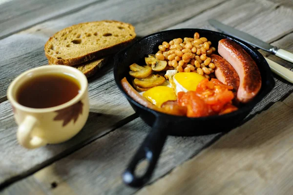 Повний ірландський сніданок зі смаженим яйцем, ковбасками, чорним пудингом, — стокове фото