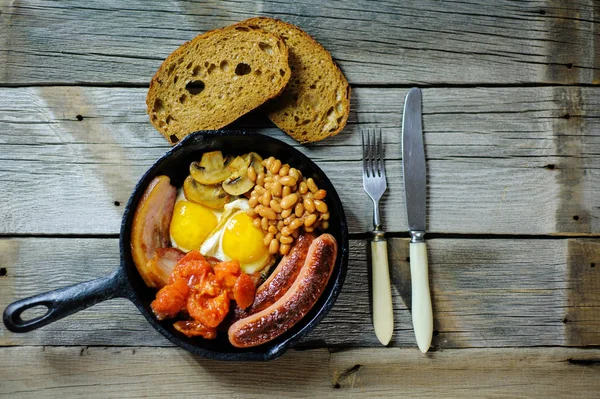 Повний ірландський сніданок зі смаженим яйцем, ковбасками, чорним пудингом, — стокове фото