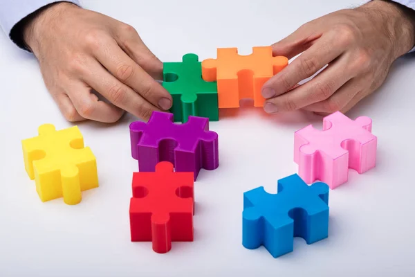 Main Personne Résoudre Puzzle Multicolore Sur Fond Blanc — Photo