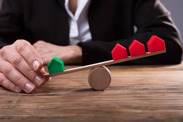 Close Dedo Humano Equilibrando Modelos Casa Seesaw Sobre Mesa Madeira — Fotografia de Stock