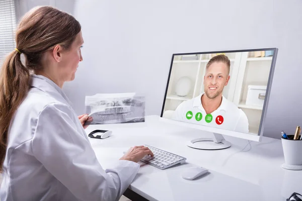 Dentista Segurando Dentes Raio Enquanto Videoconferência Com Homem Computador — Fotografia de Stock